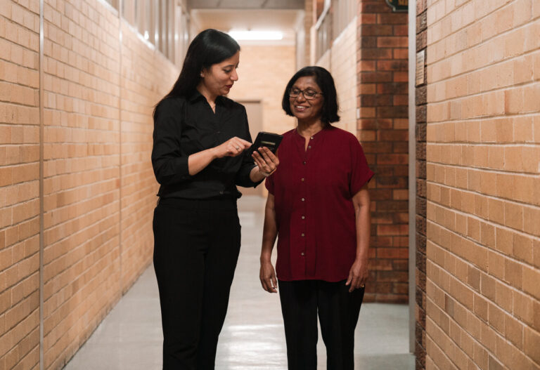 Two women chatting and looking a mobile phone
