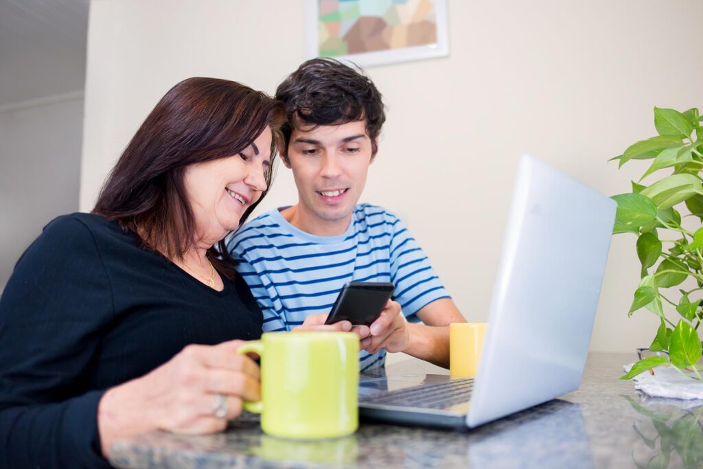 Mother and son looking at their devices together